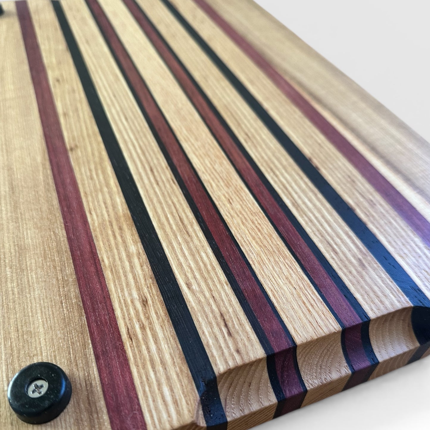 Wooden cutting board with striped pattern on a white surface