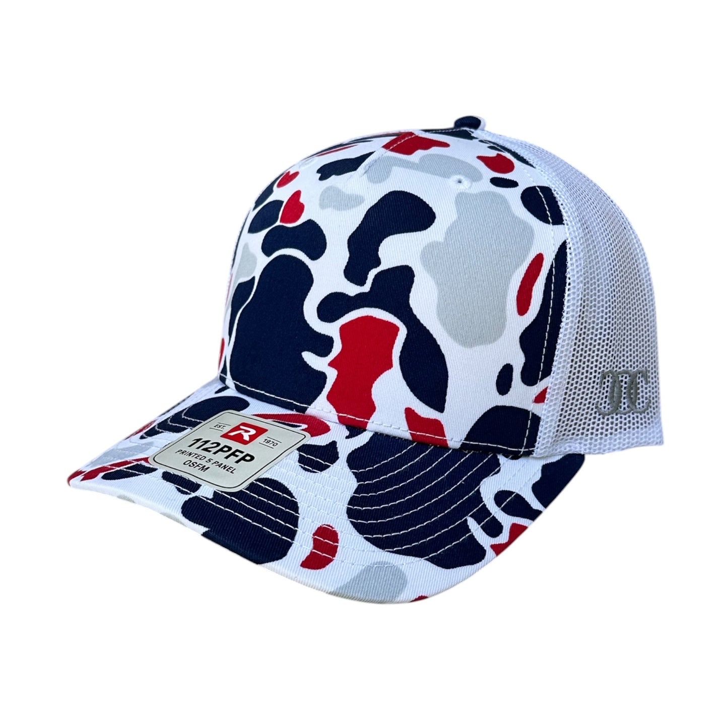 A trucker-style baseball cap featuring a white, navy blue, and red abstract camouflage pattern on the front panel and visor, with a white mesh back. A brand patch for 'Richardson' is visible on the visor. On a white background