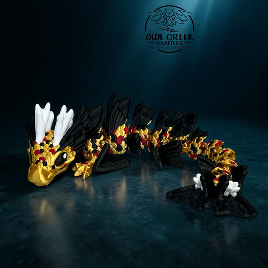 A 3D-printed articulated dragon figurine in black, gold, and white, posed on a dark reflective surface with the Owl Creek Crafters logo in the upper right.
