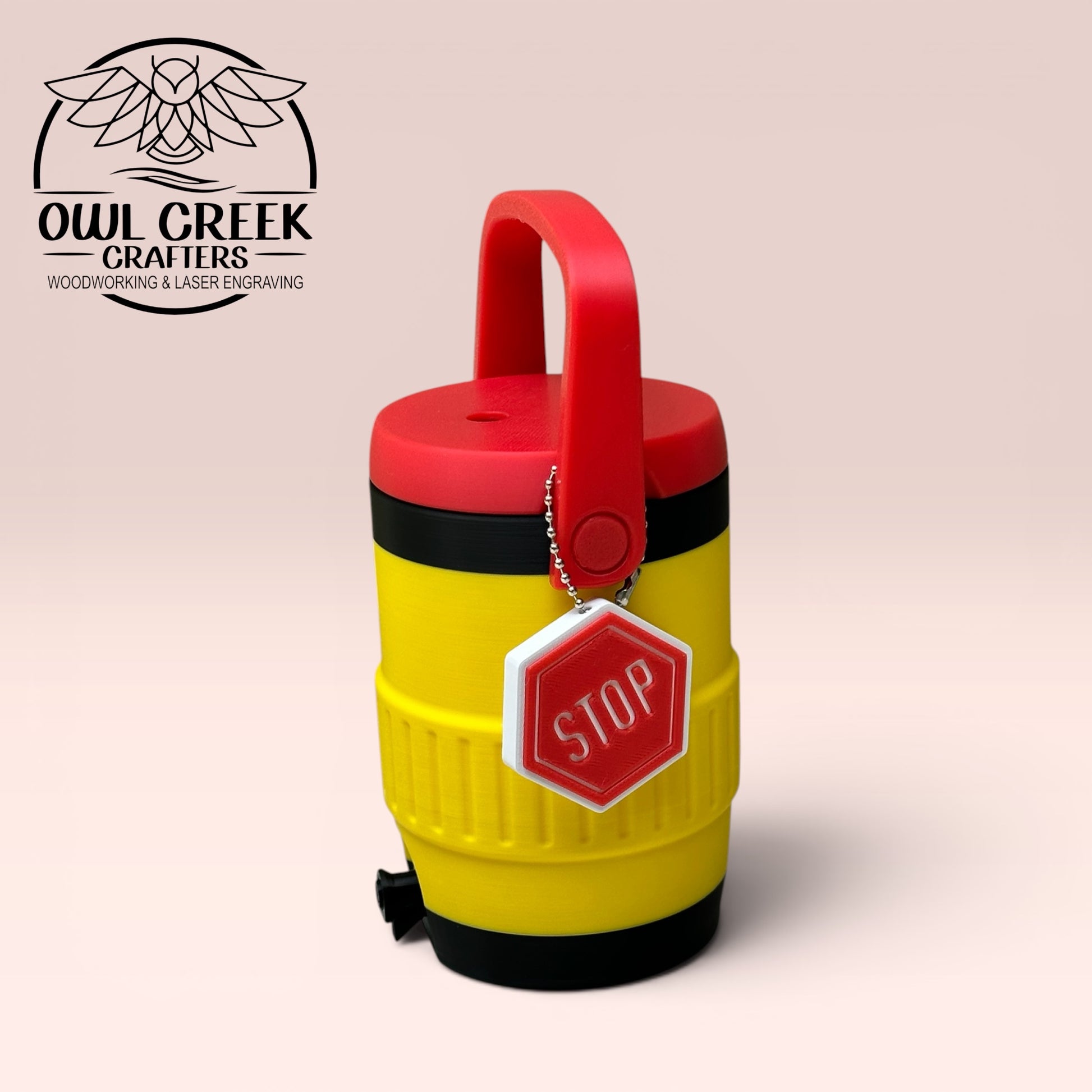 Yellow and black can cooler coozie with a red lid and handle, with a red and white 'STOP' sign keychain, on a beige background with the Owl Creek Crafters Logo