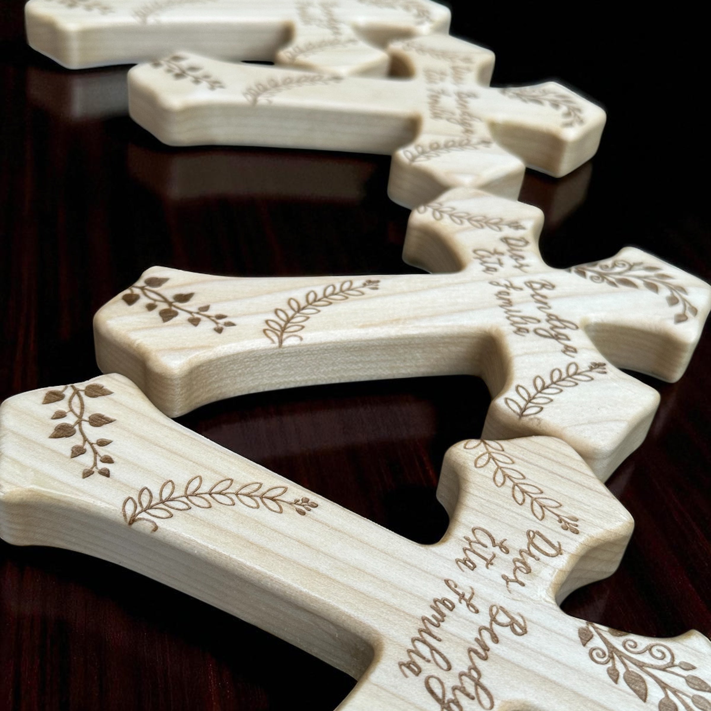 Wooden crosses with engraved designs on a dark surface