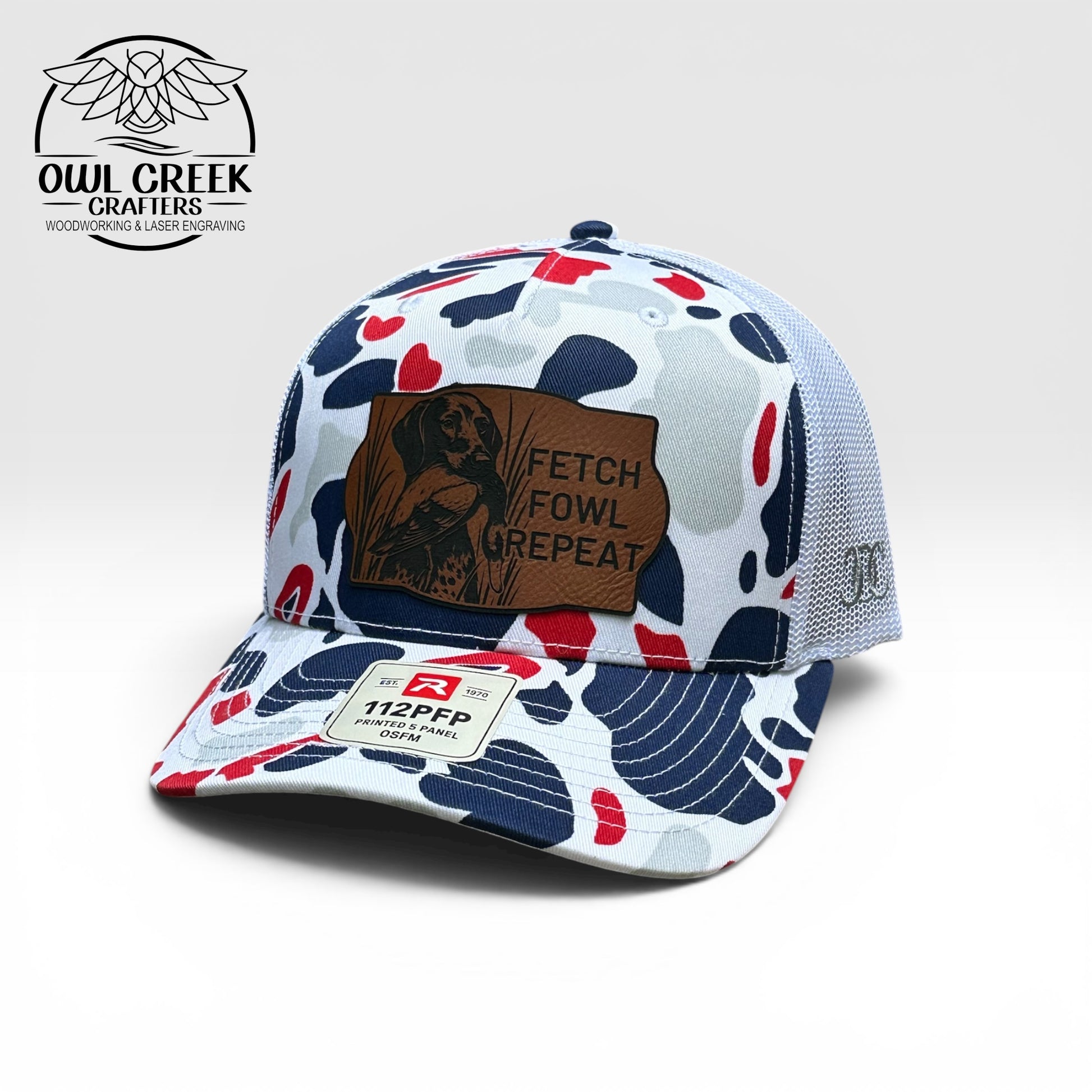 Cap with red, white, and blue camouflage pattern and leatherette patch on a white background, featuring Owl Creek Crafters logo.