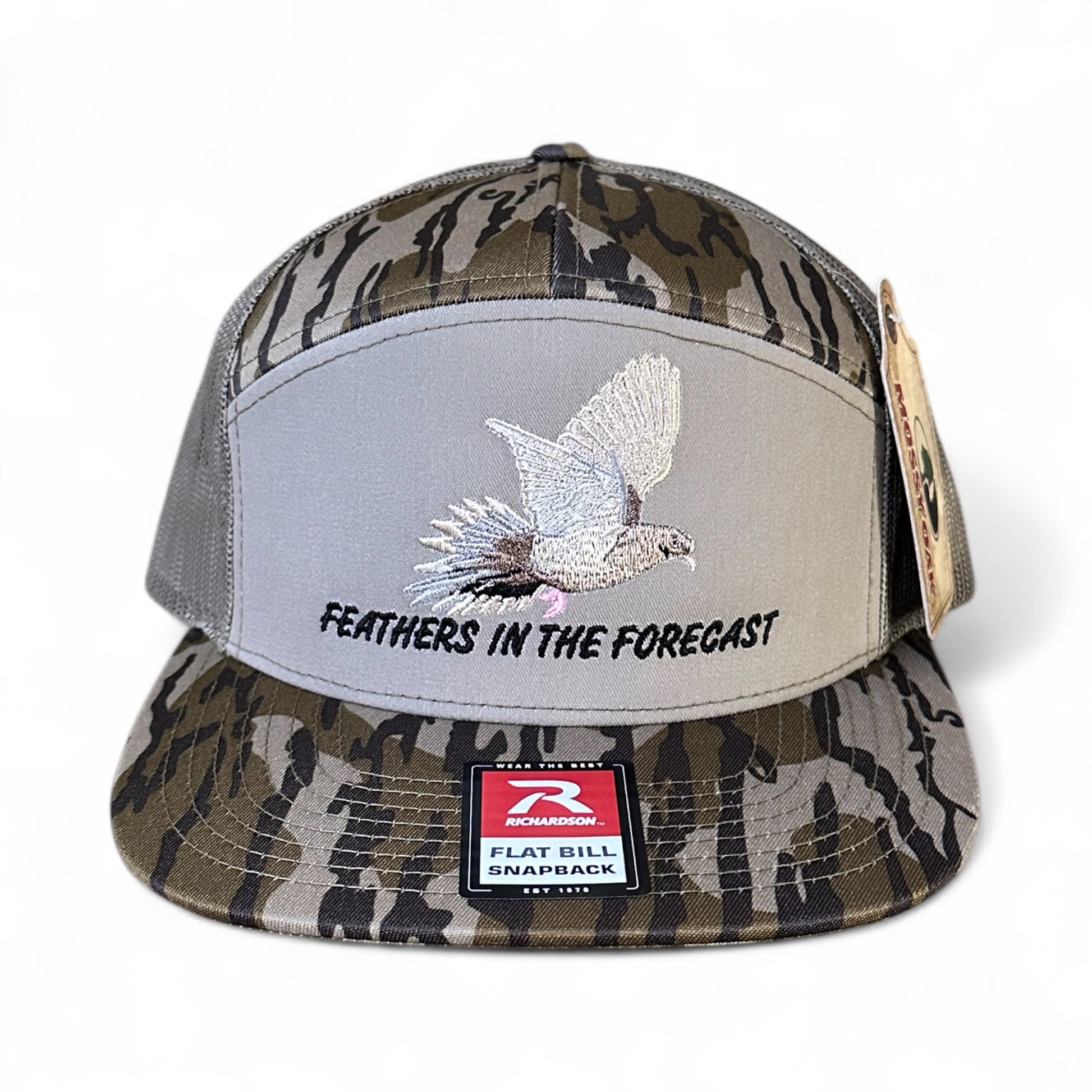 Camo trucker cap with embroidered dove design and text 'Feathers in the Forecast', with a visible brand logo label on a white background