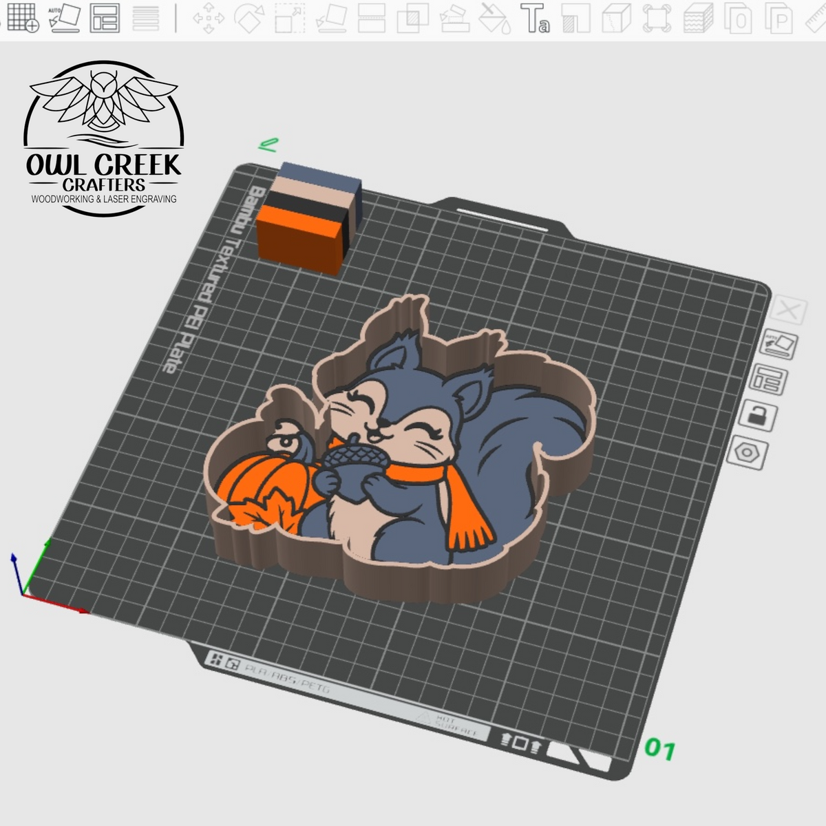 A 3D render of a trinket tray featuring a blue-gray squirrel hugging an orange pumpkin, shown on a gray gridded printing mat with the Owl Creek Crafters logo in the top left.