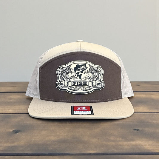 Beige and brown trucker cap with a laser engraved fish patch with the text Fish logo on a wooden surface and grey background