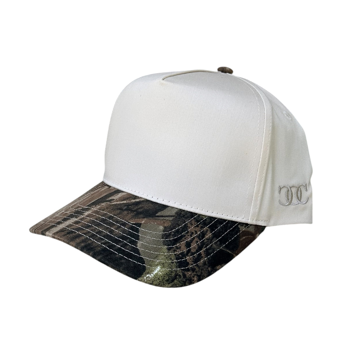 A baseball cap with a white crown and a camouflage-patterned visor, featuring a small embroidered logo on the side, on a white background