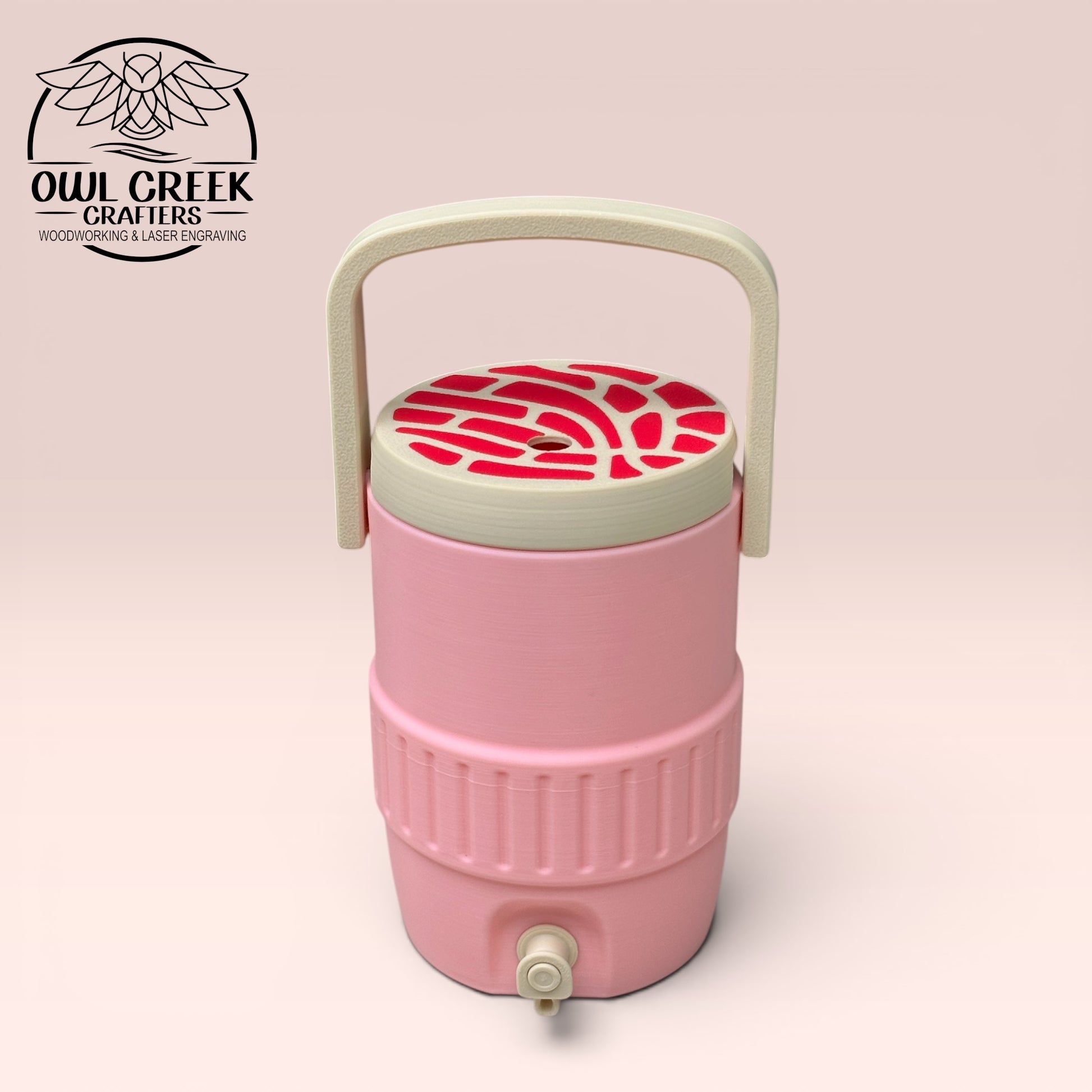 Pink can cooler coozie with a tan and  magenta lid and handle, on a beige background with the Owl Creek Crafters Logo