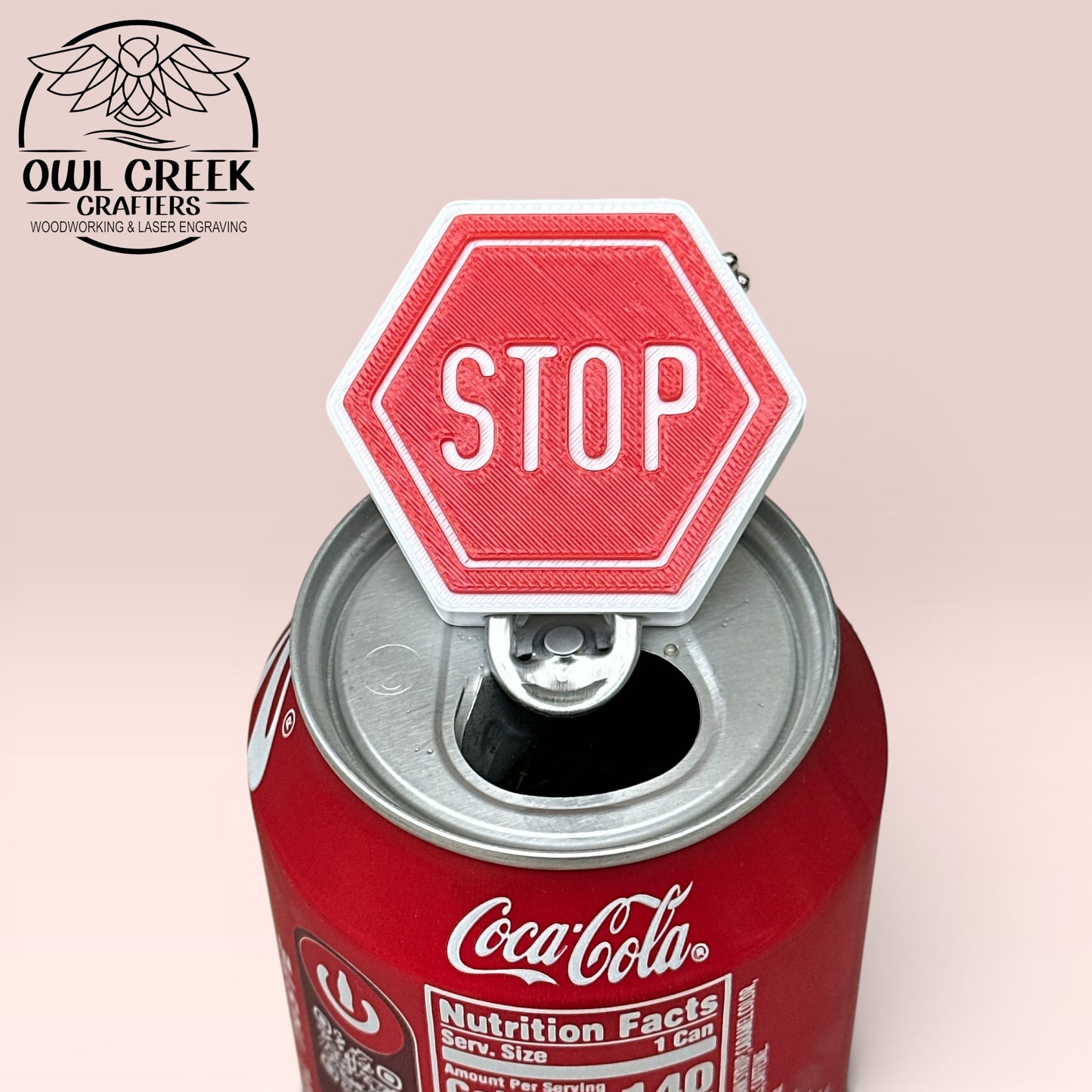 Red 'STOP' sign-shaped keychain with chain on a Coca-Cola can, with a beige background featuring Owl Creek Crafters branding.