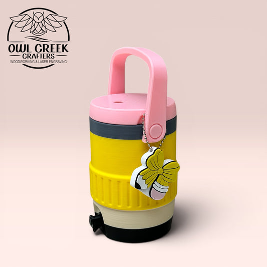 Pencil colored can cooler coozie with a pencil bow keychain, with a beige background and the Owl Creek Crafters Logo