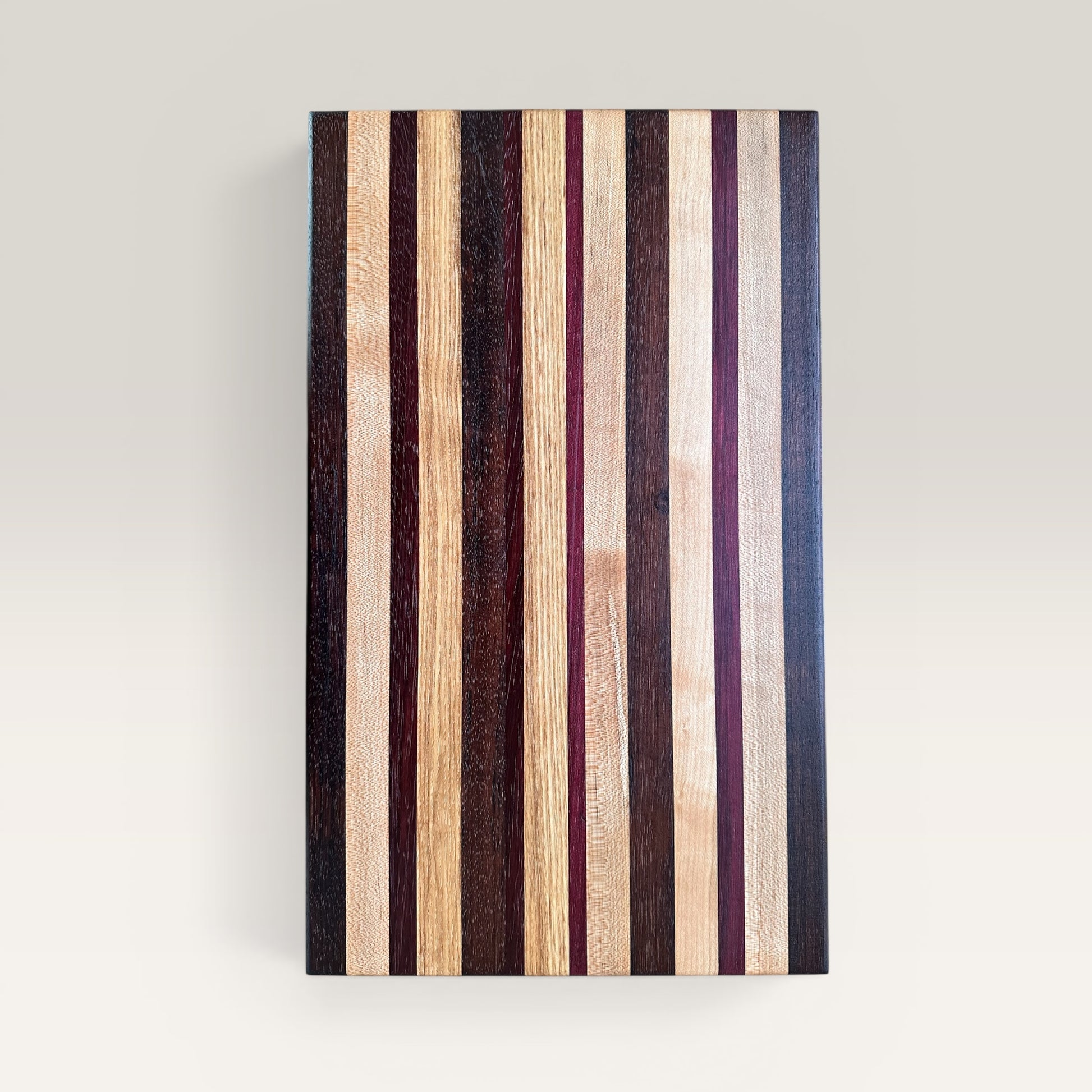 Wooden cutting board with striped pattern on a light gray background