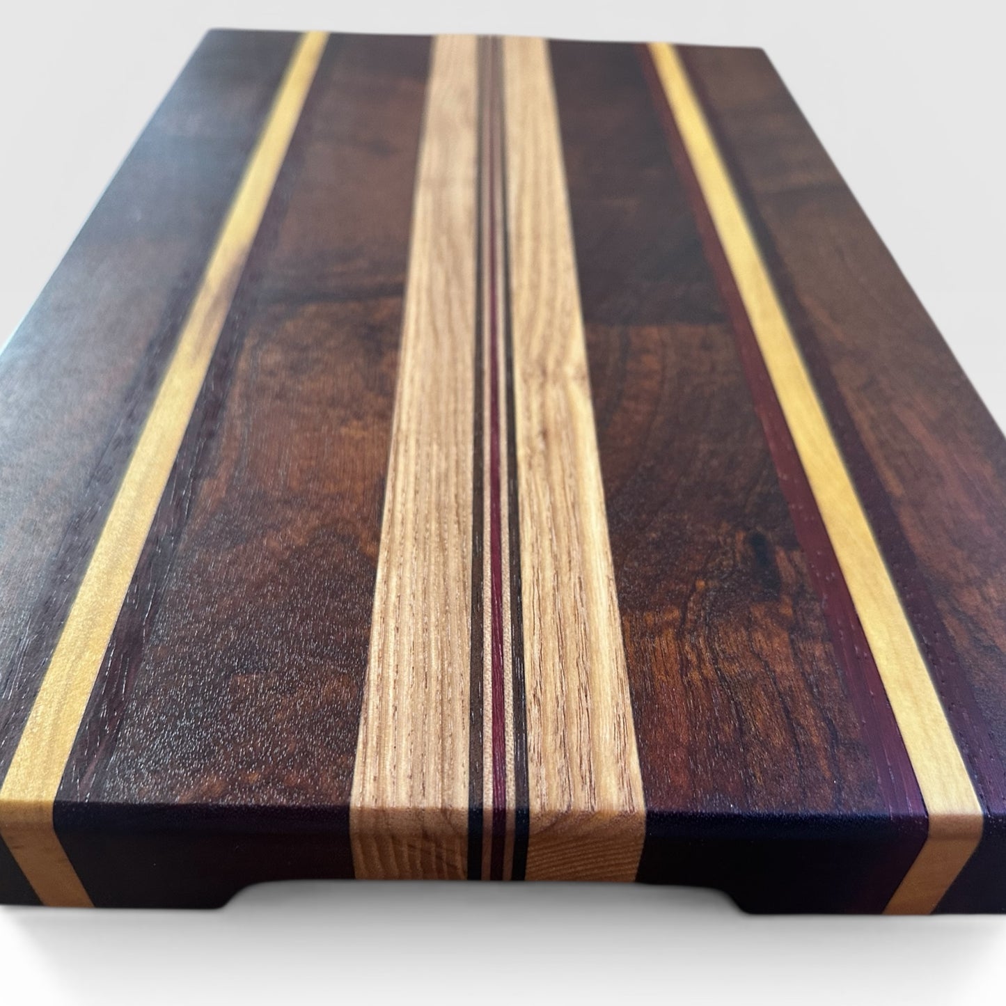 Wooden cutting board with multicolored stripes on a white background