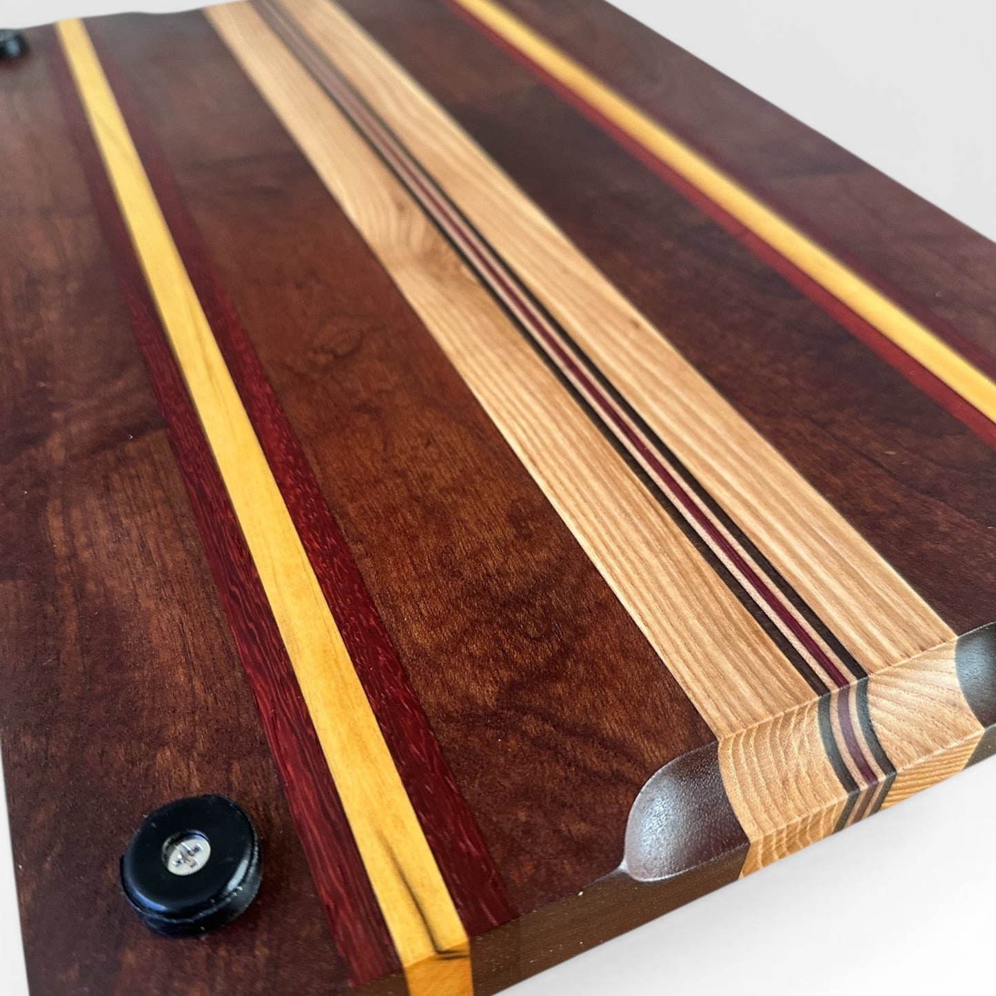 Wooden cutting board with multicolored stripes on a white background
