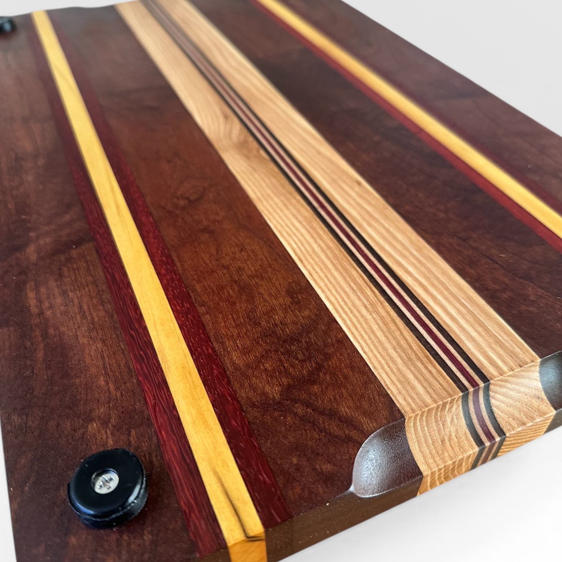 Wooden cutting board with multicolored stripes on a white background