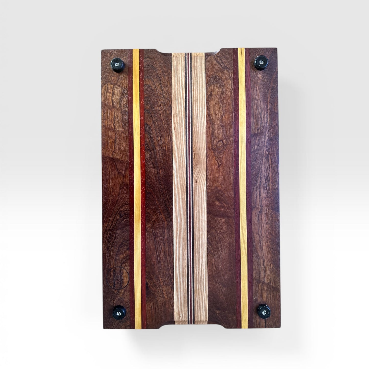 Wooden cutting board with a multi colored striped design on a white background
