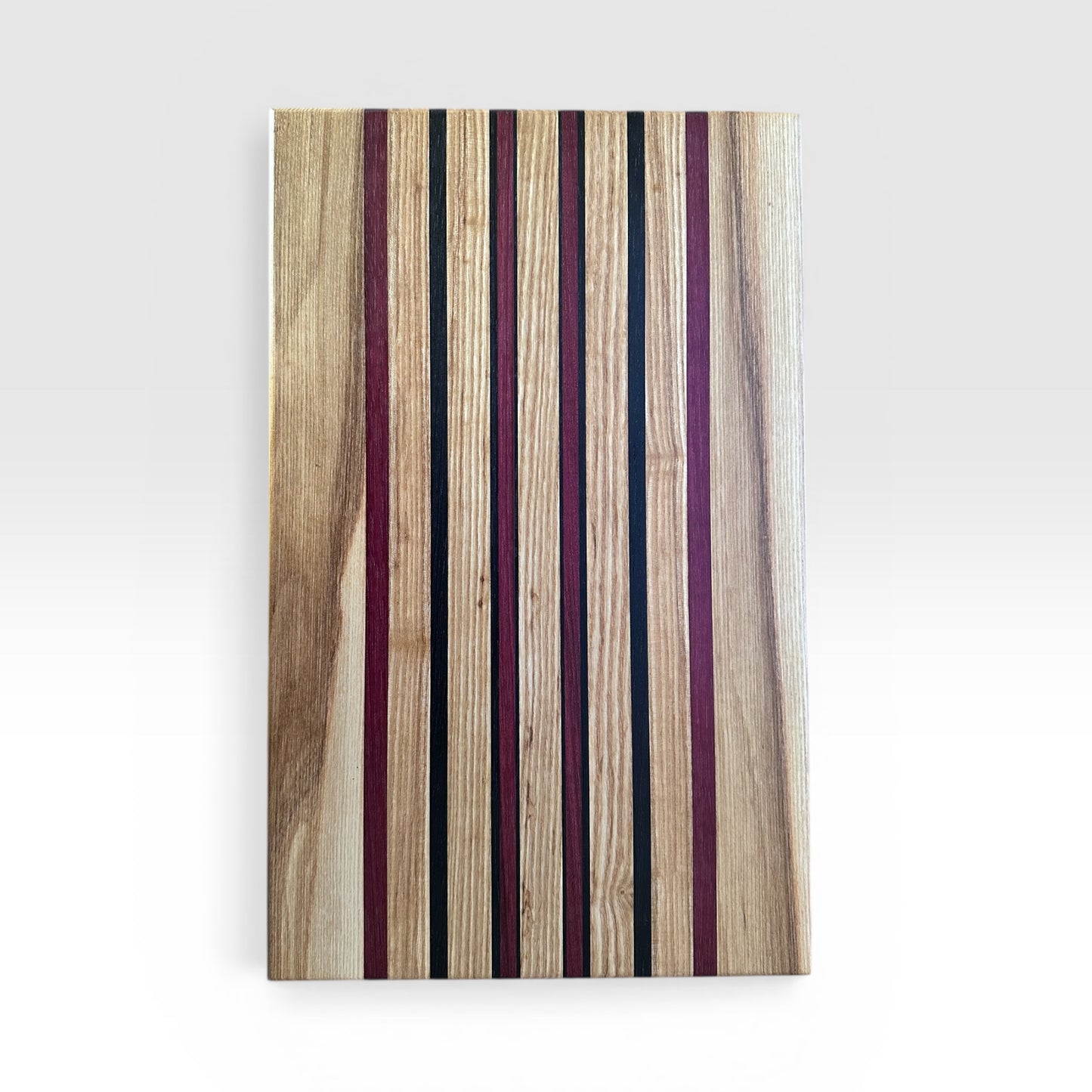 Wooden cutting board with striped pattern on a white background